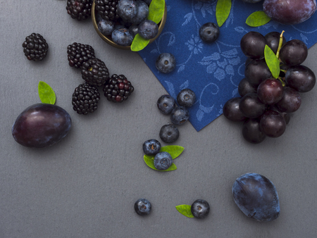 plums, grapes, blueberries and blackberries, blue fruit on the tableの写真素材
