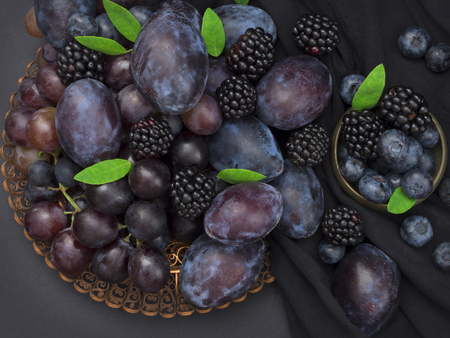 plums, grapes, blueberries and blackberries, blue fruit on the tableの写真素材