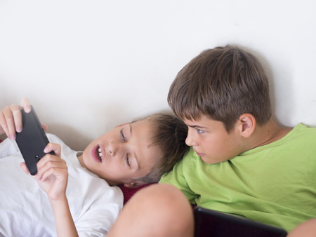 boys with devices, playing video gamesの写真素材