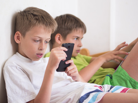 boys with devices, playing video gamesの写真素材