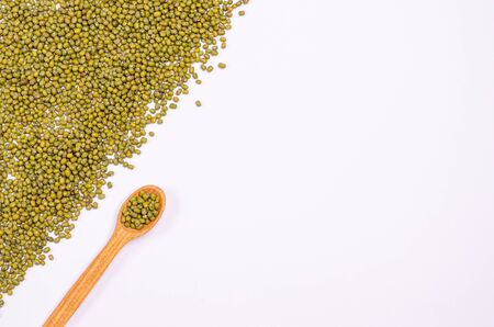 Dry green lentils for vegans in a wooden spoon on a white background. Copy space. Flat lay. Place for text. Healthy foods high in protein and carbohydrates. View from above.の写真素材