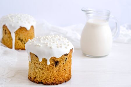 Easter cake decorated with white sugar icing and silver confectionery balls on a white background....