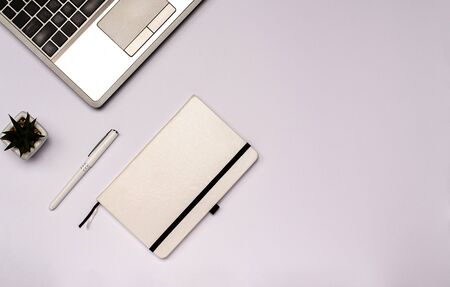 Home desktop flat lay with copy space for your text. Workspace with laptop, notebook for notes, pen, flower on a white background. View from above.の写真素材