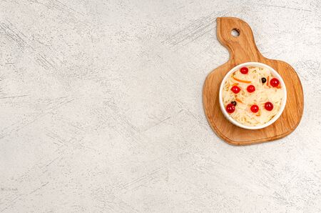 Homemade fermented sauerkraut with carrots and cranberries on the board, light gray background. Copy space. Ukrainian traditional food, concept of organic, healthy nutrition. View from above.の写真素材