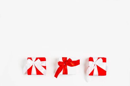 The concept of Valentine's Day, March 8, holiday, celebration, anniversary. Gift boxes with red ribbons on a white background. Free space for copy space, flat lay, top viewの写真素材