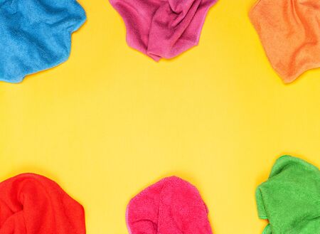 The concept of cleaning, cleanliness and hygiene. Colored rags for cleaning microfiber on a yellow background. View from above. Flat lay, copy space.の写真素材