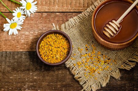 Beekeeping products honey and pollen on a wooden background. Healthy and healthy snack, healthy lifestyle, natural sweetness, dessert. Close-up. Flat lay, copy spaceの写真素材