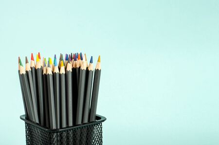 Colored pencils in a case on a blue background. A set of pencils for drawing, creativity, hobbies, classes, stationery. Flat lay, copy space, space for tex. Close-up.の写真素材