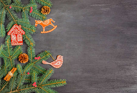 Christmas wooden toys cinnamon, cones and fir branches on a black background. Banner, form for a postcard. Copy space, flat lay. New Year, Christmas, 2021. Top view.の写真素材