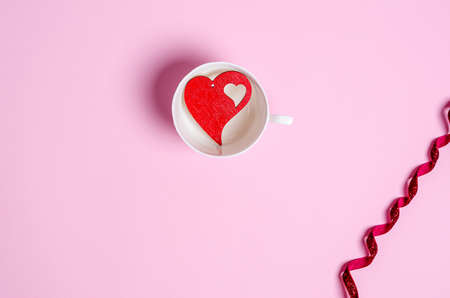 Red heart balloon on a pink background. Love concept, copy space, flat lay, place for text, banner, top view.の写真素材