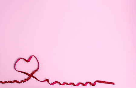 Red heart balloon on a pink background. Love concept, copy space, flat lay, place for text, banner, top view.の写真素材