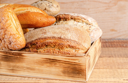 Various rustic crispy buns with bread, wheat flour, rolling pin on a black background. Copy space,...