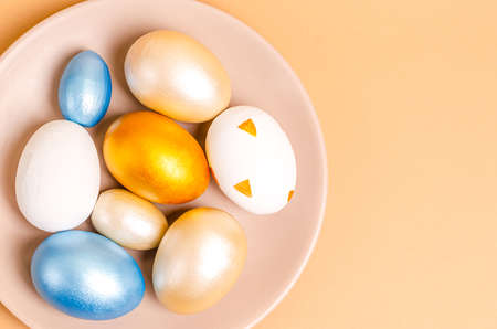 Colored eggs for Easter with branches of blossoming cherry on a blue background. Flat lay, blank for postcard, banner, copy space. Top view,の写真素材