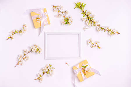 Colored eggs for Easter with branches of blossoming cherry on a blue background. Flat lay, blank for postcard, banner, copy space. Top view,の写真素材