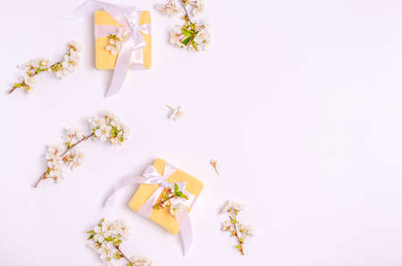 Bouquet of white tulips with gift boxes and blank paper on a blue background. Flat lay, copy space, spring concept, place for text, top view.の写真素材