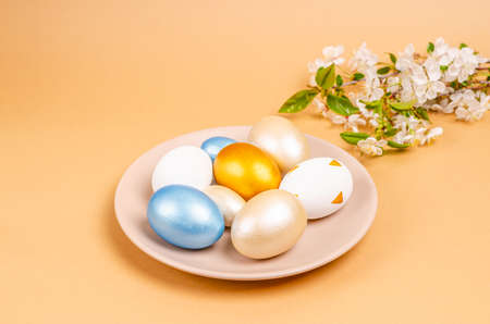 Painted eggs for Easter on a plate on a beige background with copy space. Seasonality concept,...