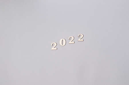 Craft postcard and wooden natural New Year's toys, numbers 2022 on a beige background, copy space....