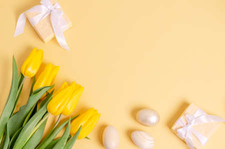 Easter egg and a wooden hare with a branch of hepsophila on a gift box on a white background. The...