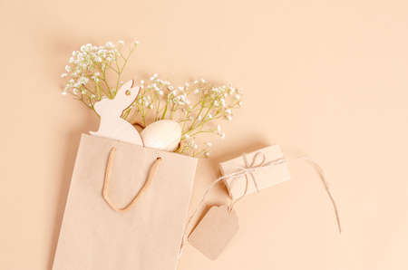 A bouquet of tulips, Easter eggs and a gift box on a yellow background. The concept of naturalness, ecology, holiday. Preparation for a postcard. Flat lay, copy space, place for text. view from above.の写真素材