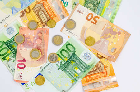Euro paper banknotes of different denominations in a child's hand on a white background. The concept...