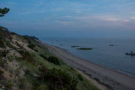 Cape Cod summer sunset over the bay with birds and boats bobbing around on the waterの写真素材