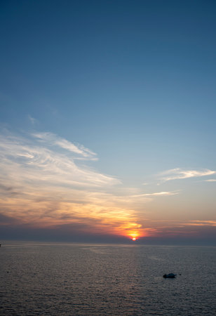 Cape Cod summer sunset over the bay with birds and boats bobbing around on the waterの写真素材