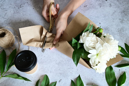 Florist makes a bouquet.a woman makes a bouquet of peonies, a bouquet of kraft paper., pruning flowers, stylite makes a bouquetの写真素材