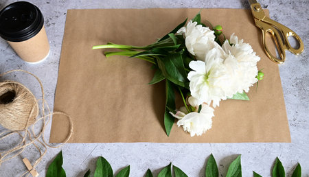 Florist makes a bouquet.a woman makes a bouquet of peonies, a bouquet of kraft paper., pruning flowers, stylite makes a bouquetの写真素材