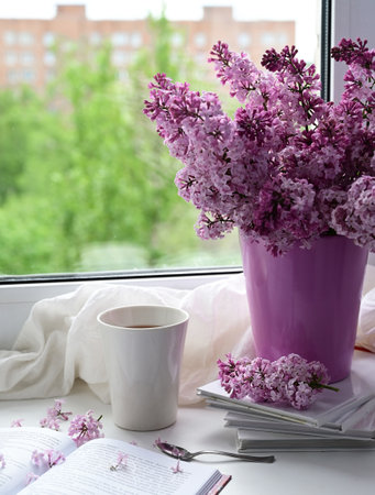 The postcard is beautiful. A mug of tea, an old book and a bouquet of purple lilac. A beautiful...