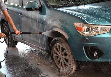 Cleaning car using active foam. Woman washing his car on self car-washingの写真素材