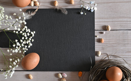 Create an Easter composition of Easter quail eggs and flowers on a white wooden background. A greeting card for the Easter holiday.Top view, copy location, flat layout.の写真素材