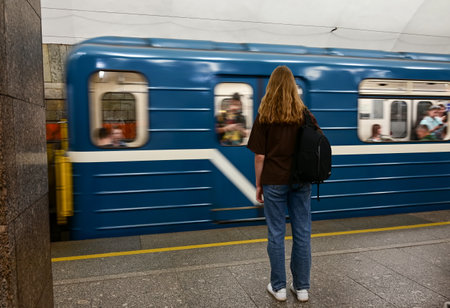 a girl with a backpack is waiting for a train at the station Outdoor adventure travel by train...