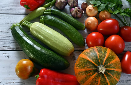 food cooking background. Fresh rosemary, cilantro, basil, cherry tomatoes, peppers and olive oil, spices herbs and vegetables at black slate table. Food ingredients top view.の写真素材
