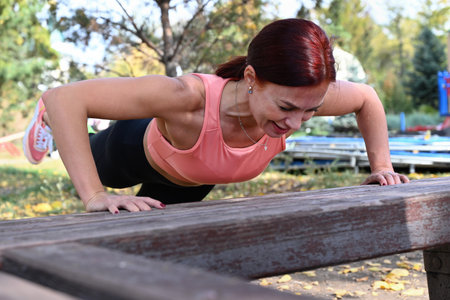 An athlete in comfortable sportswear. Outdoor fitness in the city. Healthy lifestyle. Coach exercises on the street. A confident woman does a workout.の写真素材