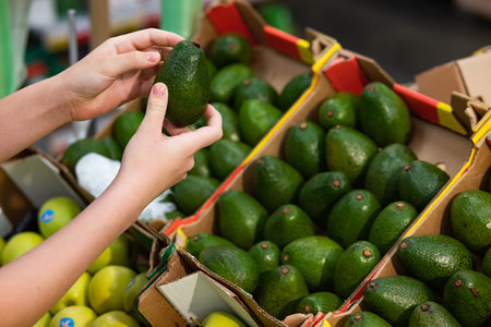 Portrait of senior Caucasian woman buying fresh organic vegetables and fruit at market place and holding bag full of healthy food.の写真素材