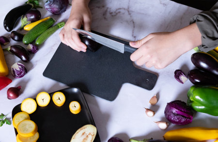 Woman cooking fresh salad with ripe red cabbage at gray tableの写真素材
