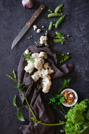 Cauliflower with vegetables and spices on a dark wood backgroundの写真素材