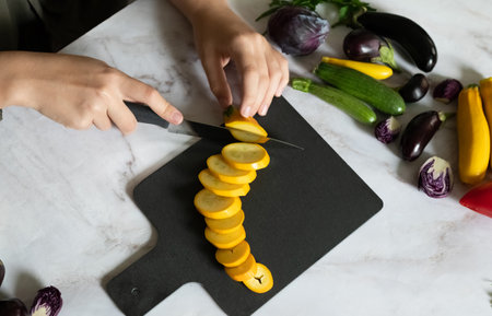 Slicing zucchini on a cutting board. Ripe zucchini on a gray background. Top view, horizontal.の写真素材
