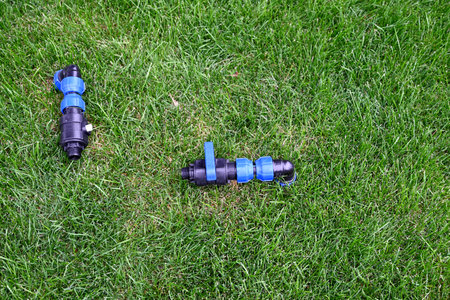 Faucet in a park to adjust water hose on it to hydrate the green grass at public park. Chrome water...