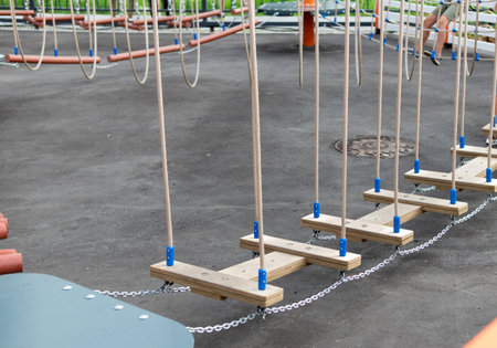Children Playground with Modern Slide, Rope Net Bridge, Climbing Swings, Climbers. Empty Wooden...