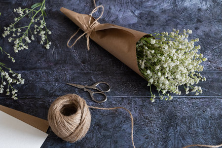 Medium height woman working with dried flowers assemble composition, decor and floristry concept