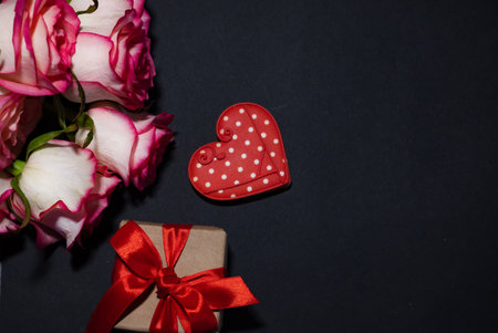 Vertical Valentines Day background with blank paper card mockup, gifts, red hearts, confetti on...