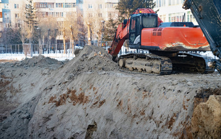 Excavator during earthmoving at open pit on blue sky background. Construction machinery and...
