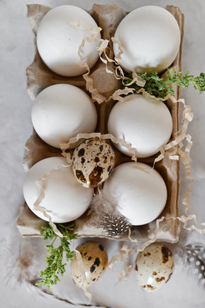 Easter eggs on rustic table with cherry blossoms. Happy Easter.Natural dyed colorful eggs in paper...