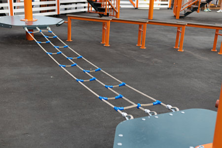 Children Playground with Modern Slide, Rope Net Bridge, Climbing Swings, Climbers. Empty Wooden...
