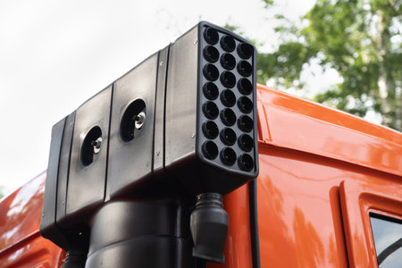 Close-up of a modern vehicle-mounted surveillance system on an orange truck.
