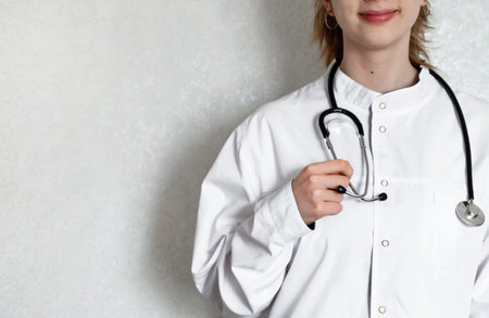 A healthcare professional is holding a clipboard and writing notes in a clinical environment. The...