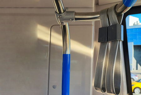 Sunlight streams through the window of a public transport vehicle, illuminating a fire extinguisher...