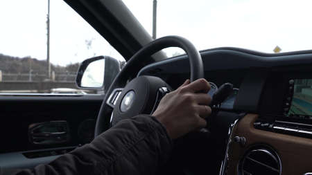 Moscow, Russia - 13 03 2020: A man drives Rolls Royce Culinan. View of hands on steering wheel.のeditorial素材