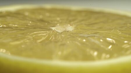Close up footage of lemon that rotates on table on white background. Fresh yellow citrus on table.の写真素材